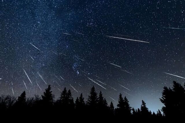 Enthusiastic stargazer tracking Lyrids meteors during a spring night observation session at a certified dark sky park.